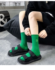 Vue street style de chaussettes montantes vert vif et sandales à plateforme noires