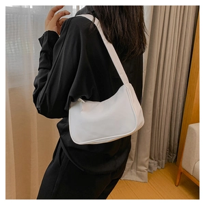 Woman wearing a sleek white minimalist crescent underarm bag with black shirt