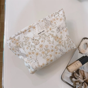 Floral makeup pouch with rabbit pattern and Simple Wish label on a clean white desk
