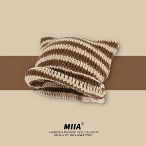 Detail of the chunky knit texture and cat ear design on the striped wool beanie