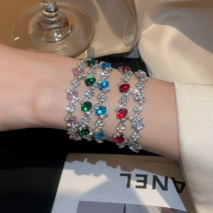 Detailed close-up of sparkling tennis bracelets with multi-colored gemstones on wrist