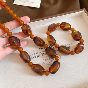 Macro shot of vintage amber acrylic irregular beads on a brown necklace set