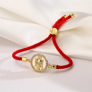 Detailed view of red woven bracelet with adjustable gold Saint Jude portrait charm