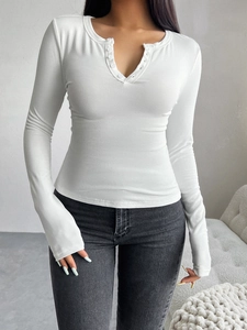 Gros plan détaillé du t-shirt blanc à col en V côtelé avec boutons et manches longues