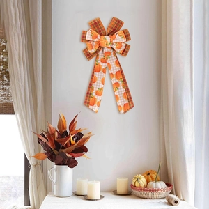 Close-up of Thanksgiving decorative bow with orange plaid and pumpkin patterns in home setting