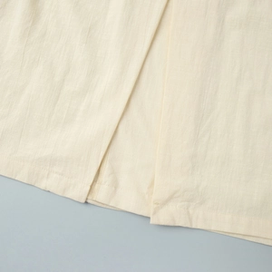 Close-up of sleeveless shirt dress showing cotton linen texture and side slit detail