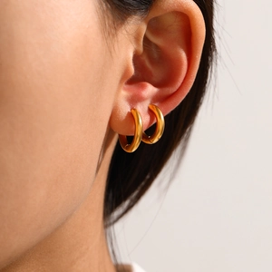 Minimalist golden geometric hoop earrings in stainless steel on female model