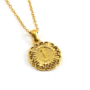 Detailed macro view of 18k gold vintage filigree round pendant with letter I engraving