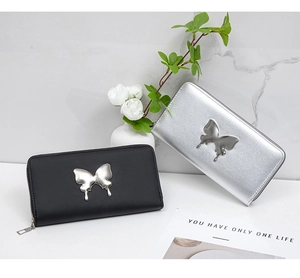 Detail of silver butterfly buckle on long leather wallets in black and silver finishes