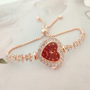 Detail of rose gold heart-shaped watch with red dial and adjustable crystal bracelet