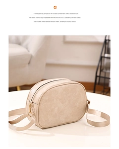 Detail of beige textured fabric shoulder bag with golden hardware and neat bag shape