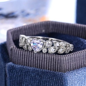 Elegant heart-shaped zircon ring with halo crystals in a blue velvet jewelry box