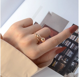 Minimalist double gold spheres open ring showcased on a model's hand for a chic style