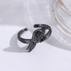 Macro detail of gothic punk open ring featuring a black raptor bird and twig texture