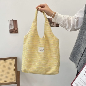 Macro shot of yellow woven tote bag texture with colorful fibers and logo patch