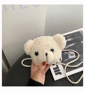 Close-up of cute white teddy bear plush crossbody bag with soft faux fur and braided strap