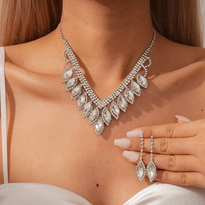 Macro shot of a sparkling rhinestone necklace and teardrop earrings set on a model
