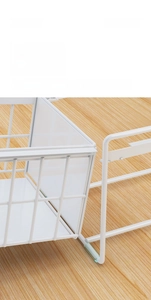 Detail view of pull-out kitchen basket with white metal wire and anti-slip feet