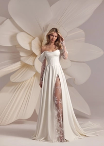 Detail of off-shoulder wedding dress with corset waist and lace sleeves on white floral background