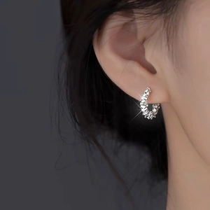 Elegant s999 sterling silver textured hoop earrings worn by a model in a side view