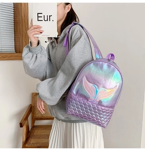 Close-up of laser shiny purple mermaid backpack featuring pink tail embroidery and scales