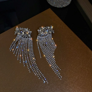 Close-up of sparkling silver tassel earrings with floral stud and crystal rhinestones
