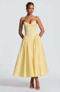 Détail de la robe d'été jaune avec corsage ajusté et taille plissée évasée élégante