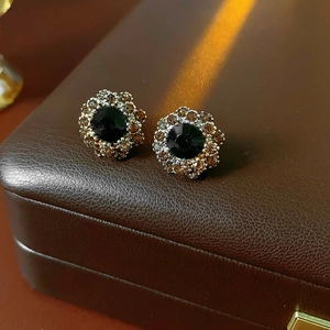 Macro shot of vintage style earrings with black gemstone and champagne crystal halo