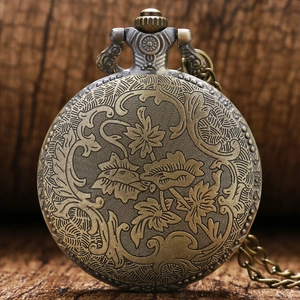 Detailed close-up of retro bronze pocket watch back with vintage floral relief patterns