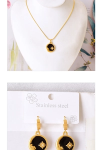 Detailed set of gold stainless steel necklace and starburst earrings with black oil drop