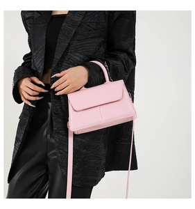 Close-up of pink PU leather crossbody bag with stylish top handle and shoulder strap