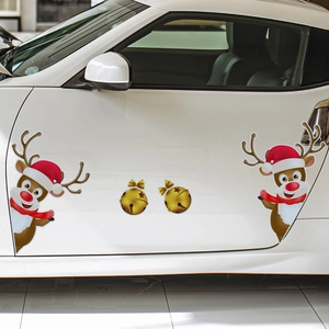 Close-up of reindeer and golden bell magnetic stickers on a white car door