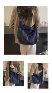 Détail d'un grand sac fourre-tout en denim bleu foncé délavé porté par un mannequin femme