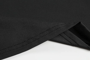 Detailed close-up of double-stitched hem on elegant black knit bodycon dress fabric