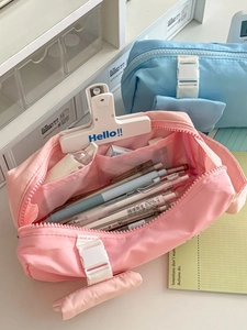 Detail of multi-layer mesh pockets inside a large capacity pink and blue canvas pencil case