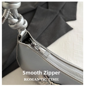 Close-up of smooth metal zipper and silver synthetic leather texture on shoulder bag