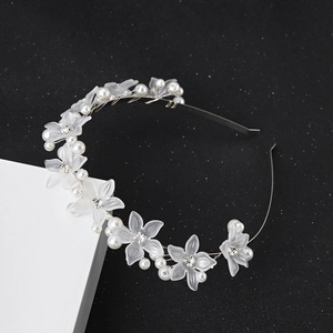 Close-up of floral hairband with frosted flowers and white pearls on a dark background