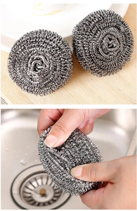 Detail of stainless steel scouring pad cleaning stubborn stains in a kitchen sink