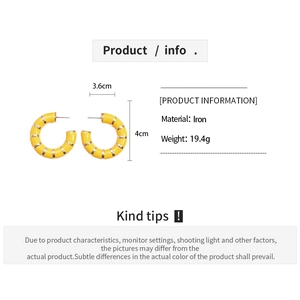 Macro view of C-shaped yellow earrings with gold metal stripes, size 3.6x4cm