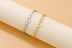 Detailed shot of textured oval link chains in gold and silver finish on a white stand