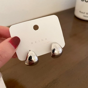 Minimalist silver twist drop earrings presented on a card with a stylish aesthetic