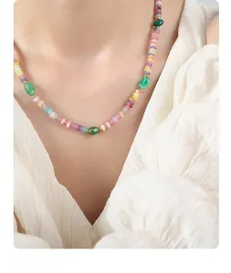Gros plan d'un collier de perles fait main avec agate verte et perles colorées sur modèle