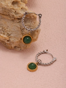 Detailed view of twist-patterned gold earrings with elegant green agate stone pendants