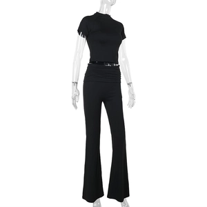 Vista dettagliata del set in maglia nera con crop top a collo alto e pantaloni a zampa a vita alta