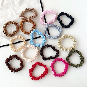 Colorful silk texture scrunchies set displayed on a canvas bag and white background