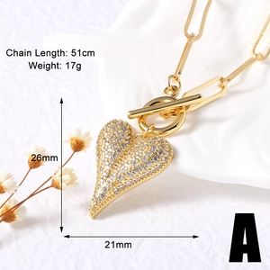 Close-up of golden heart pendant necklace with full cubic zirconia on paperclip chain