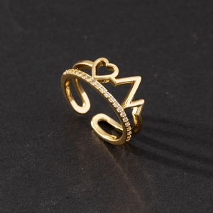 Close-up of golden crown ring with heart design and cubic zirconia on black background