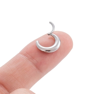 Polished silver G23 titanium crescent moon ear hoop shown on fingertip for size scale