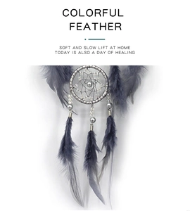 Detail of grey boho dreamcatcher featuring intricate weaving, silver beads and soft feathers