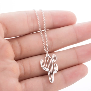 Detailed view of a hollow cactus pendant necklace in silver on a hand model